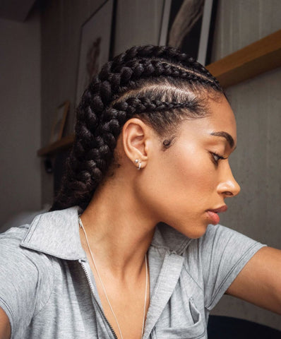 Black woman looking to the side with big chunky cornrow hairstyle